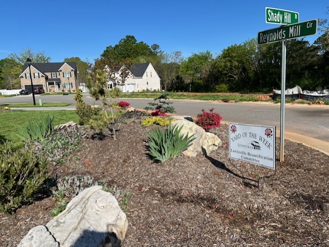 A mulch island full of colorful plants and large rocks