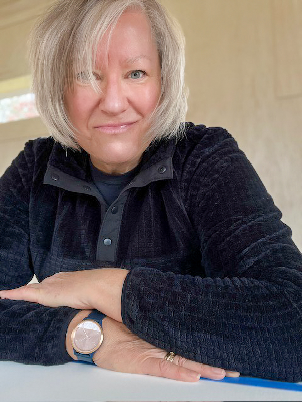 Woman with a gray bob smiles in a dark jacket