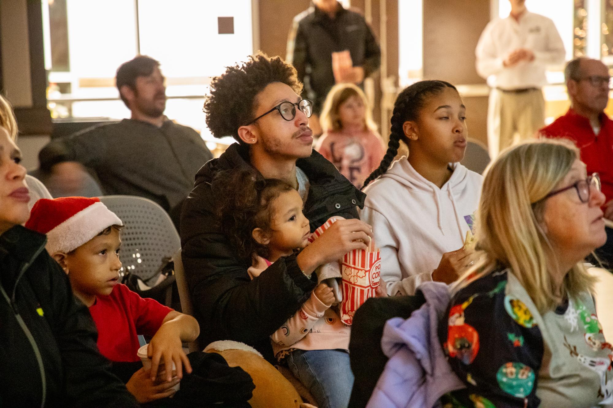 A family watches the holiday movie at the Mary Alice Warren Community Center in Lewisville.